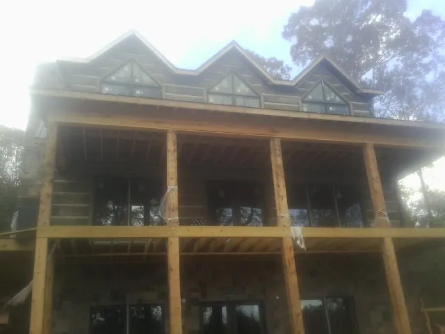 Dormers and porch framing on a large log home under construction — Roof Coating work by our crew in Citrus Heights